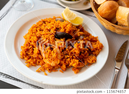 Delicious traditional Valencian seafood paella - savory rice dish with shrimps and clams Delicious traditional Valencian seafood paella - savory rice dish with shrimps and clams 115674857