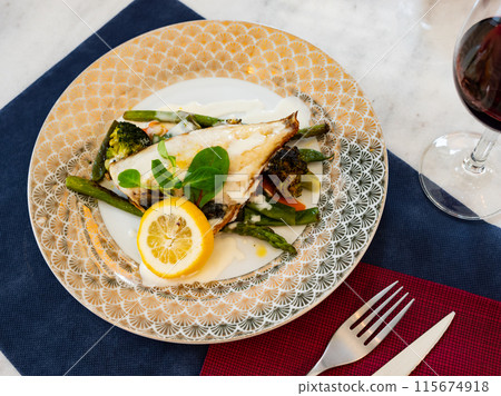 Grilled fillet of dorada with lemon, vegetables and white sauce Grilled fillet of dorada with lemon, vegetables and white sauce 115674918