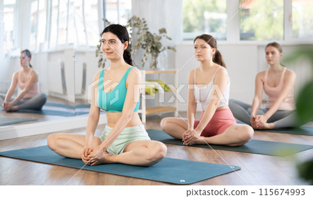 Young girl practicing Baddha Konasana at group yoga session 115674993