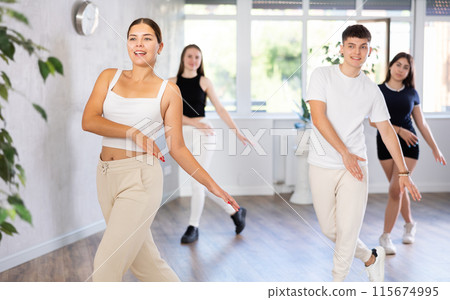 Girl teen perform choreographic exercise and teach energetic mobile social dance vogue with friends 115674995