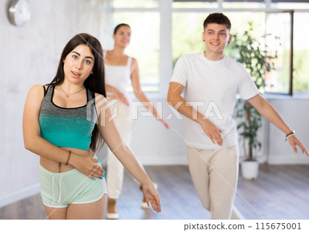 Girl teen perform choreographic exercise and teach energetic mobile social dance vogue with friends 115675001