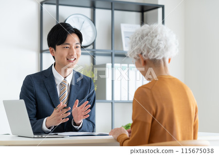 A businessman selling to a senior woman 115675038