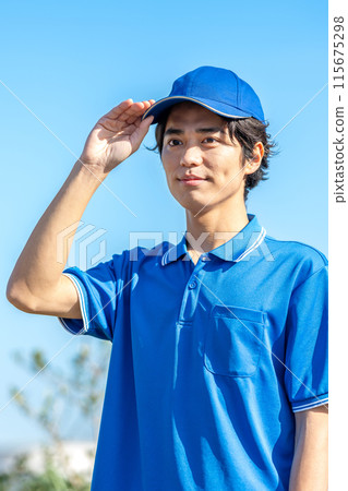 A young male driver in work clothes wearing a hat 115675298