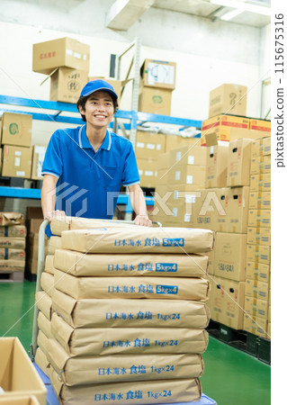 Young male driver working in warehouse Young male driver working in warehouse 115675316
