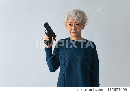 Senior woman holding a gun 115675499