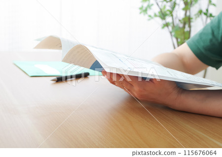 A woman looking at a pamphlet and considering an insurance contract A woman looking at a pamphlet and considering an insurance contract 115676064