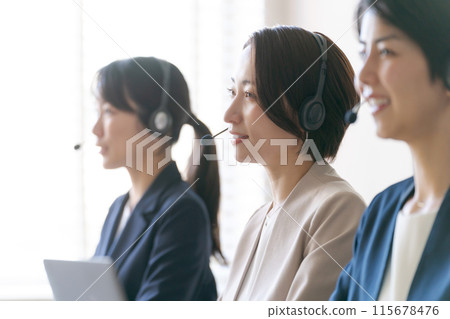 Women in a call center talking on an intercom 115678476