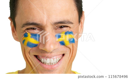 Man with a swedish flag painted on the face smiling Man with a swedish flag painted on the face smiling 115678496