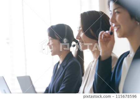 Women in a call center talking on an intercom 115678596