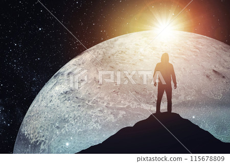 Silhouette of a man standing on the top of a mountain against the backdrop of the planet. Elements of this image furnished by NASA Silhouette of a man standing on the top of a mountain against the backdrop of the planet. Elements of this image furnished by NASA 115678809