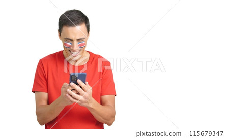 Costa Rican supporter looking at his mobile smiling and showing it. 115679347