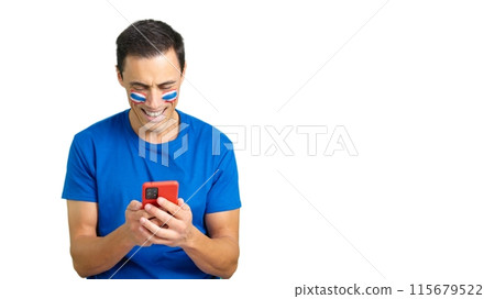 Thailand supporter looking at his mobile smiling and showing it. 115679522