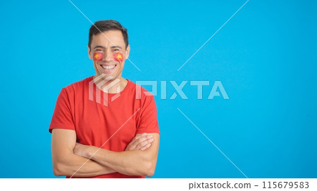 Man standing with vietnamese flag painted on face smiling 115679583