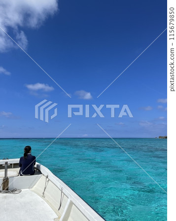 Blue sea of coral reef, people on a boat, portrait 115679850