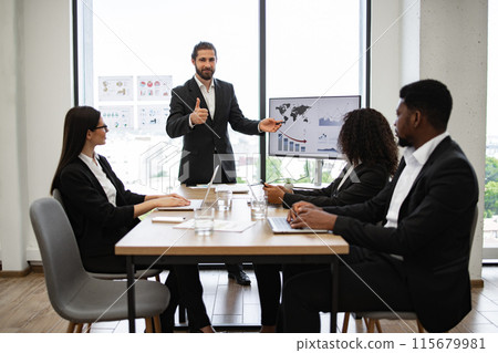 Businessman presenting sales report to colleagues in modern office 115679981