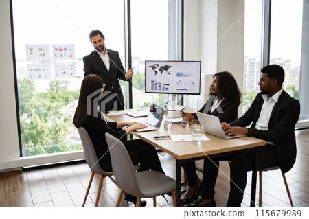 Businessman presenting to colleagues with graphs and charts on display 115679989