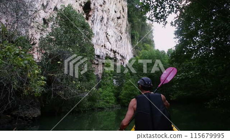 Man engages in kayaking session floating in canyon Man engages in kayaking session floating in canyon 115679995