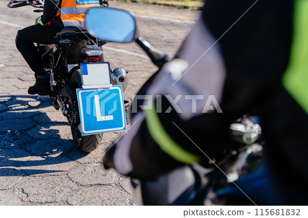 Young woman L-driver doing exercise while learning to drive before obtaining a driving license. Female passing the exam, riding with an instructor. Close up. 115681832