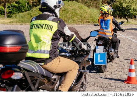 A man in a yellow jacket is riding a motorcycle with a blue license plate. He is being followed by a man in a black jacket A man in a yellow jacket is riding a motorcycle with a blue license plate. He is being followed by a man in a black jacket 115681929