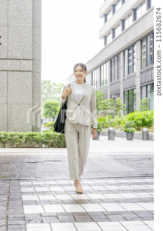 Businesswoman walking on a pedestrian crossing 115682674