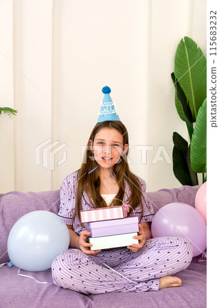 Young girl celebrating birthday at home with presents and balloons. Young girl celebrating birthday at home with presents and balloons. 115683232