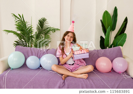 Young girl celebrating birthday at home with gifts and balloons. Young girl celebrating birthday at home with gifts and balloons. 115683891