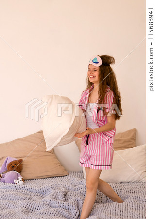 Girl playing with pillow on bed in bedroom. Girl playing with pillow on bed in bedroom. 115683941
