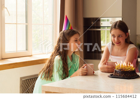 Girls birthday celebration, one blowing out candles on cake. 115684412