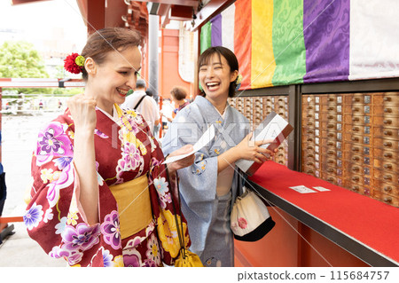 A foreign woman in a kimono drawing a fortune and a Japanese woman guiding her A foreign woman in a kimono drawing a fortune and a Japanese woman guiding her 115684757