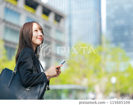 一位女商人使用背景新鮮綠色的智慧型手機 115685109