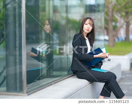 在街角看文件的女商人 115685123