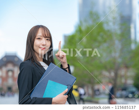 Female business woman pointing at something on a street corner Female business woman pointing at something on a street corner 115685137