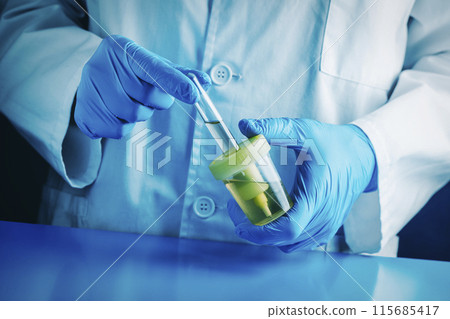 man filling a tube with a urine sample in the lab man filling a tube with a urine sample in the lab 115685417
