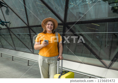 Happy traveling Caucasian woman in stylish casual clothes and hat uses mobile smartphone, checking trip destination on Internet. Female waiting at flight gates for plane boarding, smiling have a Happy traveling Caucasian woman in stylish casual clothes and hat uses mobile smartphone, checking trip destination on Internet. Female waiting at flight gates for plane boarding, smiling have a 115685472