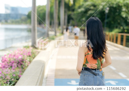 A young woman in orange dress enjoying the freedom of the outdoors, radiating joy and carefree elegance. A young woman in orange dress enjoying the freedom of the outdoors, radiating joy and carefree elegance. 115686292