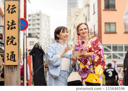 A foreign woman in a kimono sightseeing in Asakusa and a Japanese woman guiding her 115686596