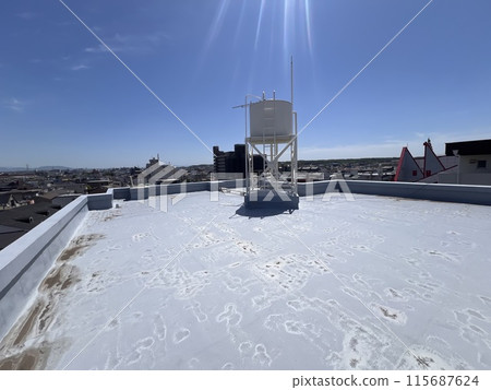 An elevated water tank on the roof of an apartment building. An elevated water tank on the roof of an apartment building. 115687624