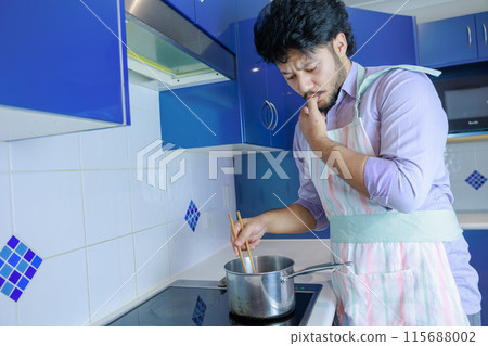Man tasting food in the kitchen 115688002