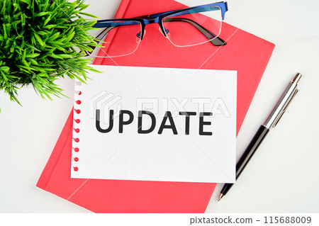 Text UPDATE written on a torn piece of paper lying on a notebook Text UPDATE written on a torn piece of paper lying on a notebook 115688009