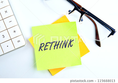 Rethink Business Concept text the inscription on the sticker on a light background next to the clock and calculator 115688013