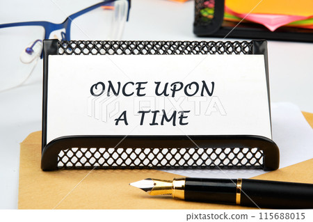 Once upon a time text the inscription on the business card on the table near the pen, a calculator, a stand with a ticker Once upon a time text the inscription on the business card on the table near the pen, a calculator, a stand with a ticker 115688015