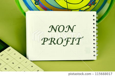 Accounting concept. Text NON PROFIT on a notepad on the background of a clock next to a calculator Accounting concept. Text NON PROFIT on a notepad on the background of a clock next to a calculator 115688017