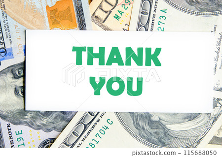 Expressing gratitude, acknowledgment and appreciation. Thank you message on a white business card against a background of dollar bills Expressing gratitude, acknowledgment and appreciation. Thank you message on a white business card against a background of dollar bills 115688050