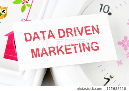 Business concept. Data driven marketing text on the business card on the background of the clock Business concept. Data driven marketing text on the business card on the background of the clock 115688216