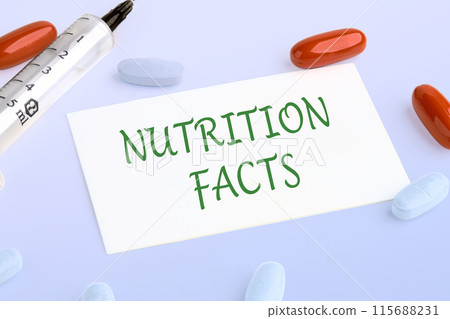 Nutrition facts text written on the business card next to pills, vitamins and a syringe Nutrition facts text written on the business card next to pills, vitamins and a syringe 115688231