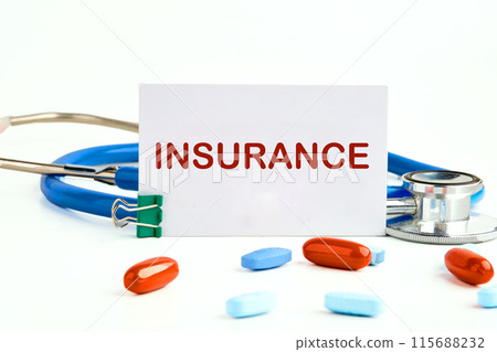 INSURANCE text on a business card next to a stethoscope with pills, vitamins INSURANCE text on a business card next to a stethoscope with pills, vitamins 115688232