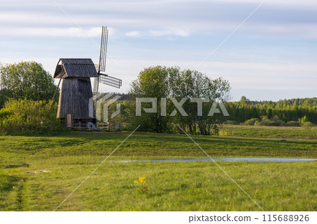 Rural Russian landscape with an old wooden windmill on the coast of Sorot river 115688926