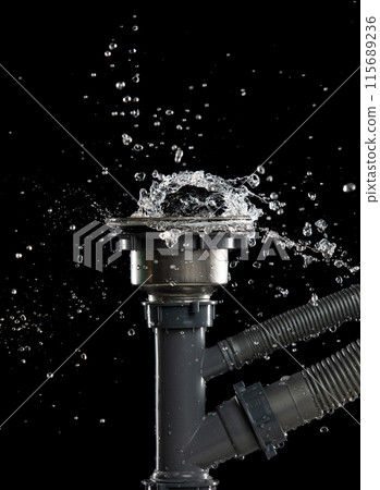 Drain sink leak water from pipe plumbing in bathroom as water splash clogged drop. Pouring Leaking water from gray plastic pipe drain sink. Black background isolated 115689236