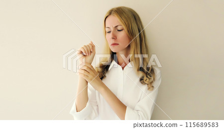 Unhealthy young woman suffers from wrist pain, tunnel syndrome, unwell girl touching her hand 115689583