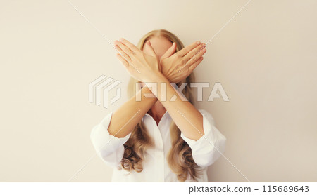 Upset woman shows stop, no or enough sign with palm of hand, refusal gesture, domestic violence 115689643